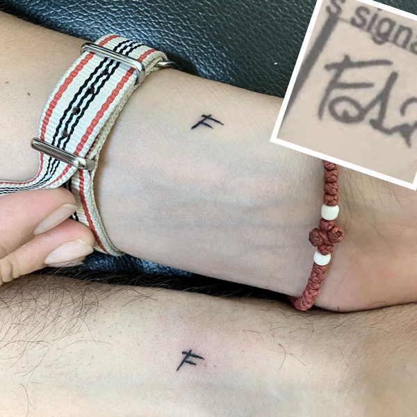 F raidės tatuiruotė prie riešo