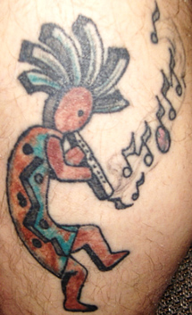 Fleitos dainuojanti Kokopelli tatuiruotė